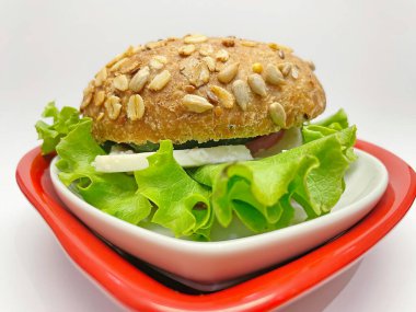 Kalp şeklinde tabakta sandviç yemeye hazır.