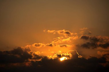 Altın Güneş ve Kara Bulutlar ile dramatik Günbatımı Gökyüzü. Yoğun, güzel doğa arkaplanı. Sıcak turuncu, altın ve koyu renkler. Karanlık, fırtınalı bulutlardan süzülen parlak güneşli dramatik ve yoğun günbatımı..