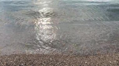 Güzel Kum 'da yumuşak deniz suyu. Temiz ve sığ suların doğal kumsalda yıkandığı sakin bir yer. Arka plan, doğa ve seyahat konuları için ideal. Deniz kıyısının sakin, yakın çekim sahnesi..