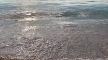 Güzel Kum 'da yumuşak deniz suyu. Temiz ve sığ suların doğal kumsalda yıkandığı sakin bir yer. Arka plan, doğa ve seyahat konuları için ideal. Deniz kıyısının sakin, yakın çekim sahnesi..