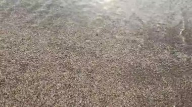 Güzel Kum 'da yumuşak deniz suyu. Temiz ve sığ suların doğal kumsalda yıkandığı sakin bir yer. Arka plan, doğa ve seyahat konuları için ideal. Deniz kıyısının sakin, yakın çekim sahnesi..