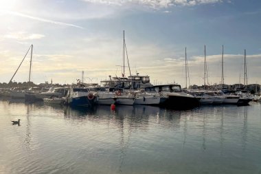 İstanbul, Türkiye. 6 Aralık 2025. İstanbul 'un bir banliyö ilçesi olan Yesilkoy sahilinden hafta sonu manzarası, kışın tekneler ve insanlarla parçalı bulutlu bir günde. Sahil boyunca uzanan sakin, mavi bir kış haftasonu sahili manzarası..