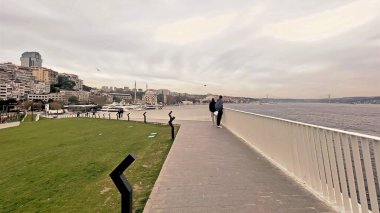 İstanbul, Türkiye. 5 Aralık 2025. İstanbul 'daki Kabatas Feribot Terminali ve Boğaz Sahil Hattı. Kabatas rıhtımında feribotları kenetlenmiş modern yaya geçidi. Yeni yenilenmiş Kabatas kıyı şeridi ve yolcu feribot merkezinin manzarası..