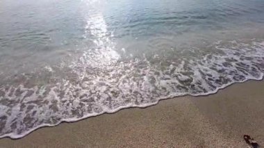 Kristal berrak okyanus dalgaları kumsala vuruyor. Gün batımında yumuşak şeffaf deniz dalgaları çakıllı bir sahilde süzülüyor. Huzurlu yaz kıyı doğası geçmişi.