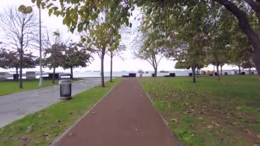 Bekir, İstanbul.Türkiye. 23 Aralık 2025, Bakırköy, İstanbul. Marmara Denizi boyunca uzanan sarı yapraklı ağaçlarla kaplı sakin bir yürüyüş yolu, Türkiye 'de kışın huzurlu bir şekilde düşüşünü yakalıyor..