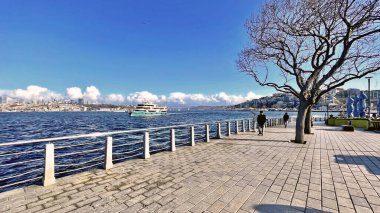 Uskudar, İstanbul, Türkiye. 1 Ocak 2026. İstanbul 'un tarihi ve turistik bir bölgesi olan Uskudar kıyı şeridi. Soğuk bir kış günü ve açık mavi bir gökyüzü. Uskudar kıyısından modern binalarıyla İstanbul ve Boğaz manzarası.