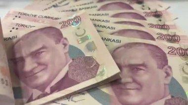 200 lira 'lık banknot yığını. Atatürk 'ün yer aldığı 200 Türk Lirası banknotunun yakın çekimi. Beyaz zemin üzerinde yüksek değerli para yığını. Yüksek çözünürlüklü, 200 lira banknotluk yoğun bir yığının profesyonel video görüntüleri..