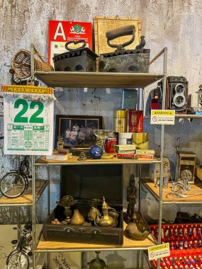 Endüstriyel metal raflarda gösterilen antika koleksiyonu, daktilo, abaküs ve dekoratif antikalar..