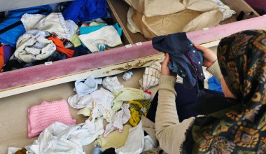 Bir kadın temiz giysileri katlar, katlar.,