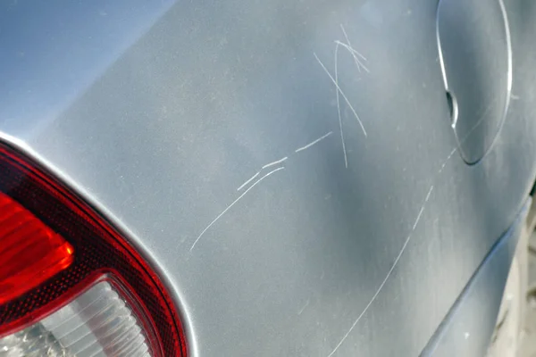 a scratched car hood, deep hood scratch,