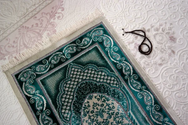 Yakın plan yeşil halılar ve tespih, ramazan ayında dua etmek.