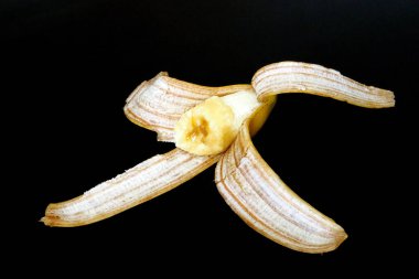 Muz kabuğu, siyah arka planda yarım muz kabuğu.,