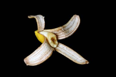Muz kabuğu, siyah arka planda yarım muz kabuğu.,