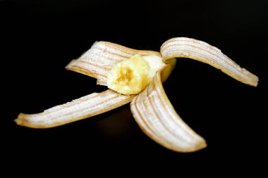 Muz kabuğu, siyah arka planda yarım muz kabuğu.,