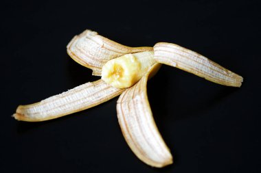 Muz kabuğu, siyah arka planda yarım muz kabuğu.,