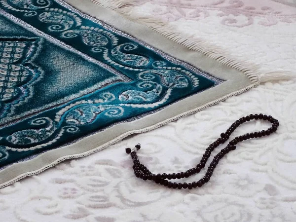 prayer mat and rosary laid on the ground for worship, prayer rug in islam,