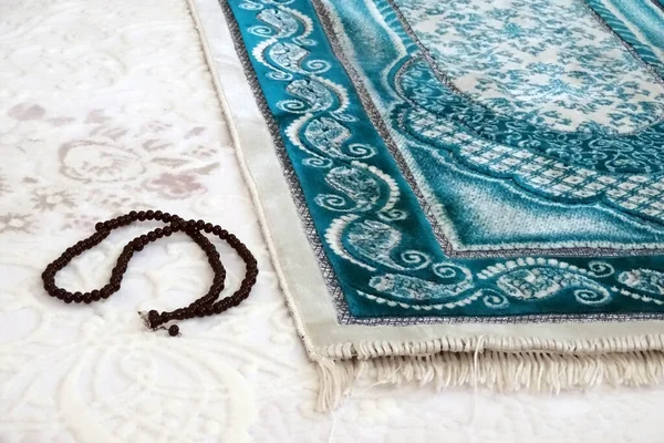 prayer mat and rosary laid on the ground for worship, prayer rug in islam,