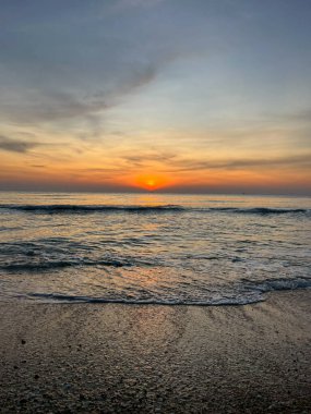 Deniz, kum ve sabah dalgalar, güneş ışığı.