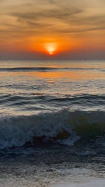 Deniz, kum ve sabah dalgalar, güneş ışığı.