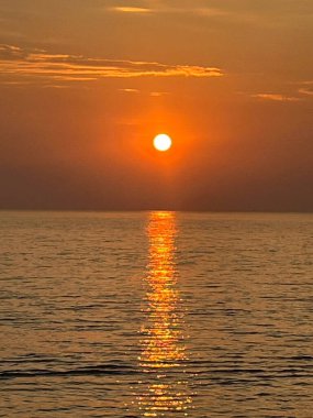 Deniz, sahil, sabah güneşi.