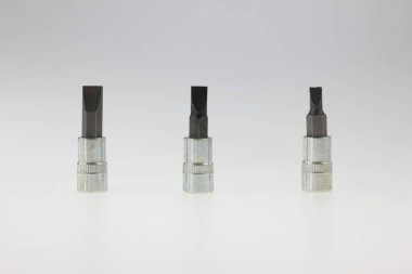 Üç düz tornavida parçası, mekanik bağlama, endüstriyel bakım, otomotiv tamiri, atölye mühendisliği ve profesyonel donanım uygulamaları için sertleştirilmiş çelik el araçlarını temsil eden, beyaz bir arka planda dik bir şekilde yerleştirilmiş.