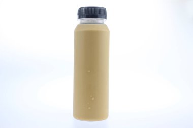 Soğuk kahve ile dolu şeffaf plastik şişe ya da temiz beyaz arka planda izole edilmiş buzlu kahve içmeye hazır. Minimalist kompozisyonda siyah vida kapaklı şeffaf bir içecek kabı vurgulanıyor, pürüzsüz kahverengi kahve sergileniyor