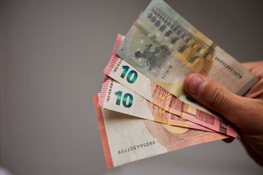 Avro banknotlarının el ele tutuştuğu yakın plan. Para, finans, tasarruf, gelir, nakit ödeme, ekonomi, zenginlik ve mali başarı kavramı. İş, bankacılık, yatırım ve ekonomik temalar için elverişli