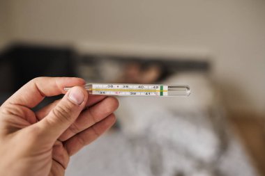 Bir elde tutulan dijital termometrenin yakın çekimi, vücut ısısını ölçmek için kullanılır. Sağlık, hastalık, ateş, tıbbi teşhis, evde tedavi ve sağlık izleme kavramı. Tıbbi ve sağlık için uygun temiz ve minimal bileşim