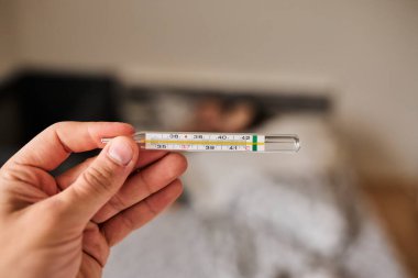 Bir elde tutulan dijital termometrenin yakın çekimi, vücut ısısını ölçmek için kullanılır. Sağlık, hastalık, ateş, tıbbi teşhis, evde tedavi ve sağlık izleme kavramı. Tıbbi ve sağlık için uygun temiz ve minimal bileşim