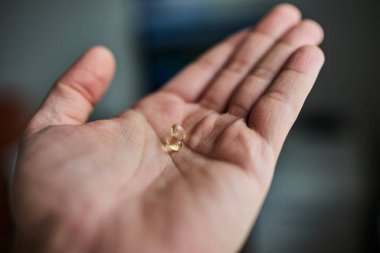 Avuç içlerine sergilenmiş D vitamini hapları. Sağlık sigortası, bağışıklık desteği, beslenme takviyeleri, sağlık ve sağlıklı yaşam tarzı kavramı. Tıbbi, farmasötik ve besinle ilgili konular için uygun temiz ve minimal bileşim.