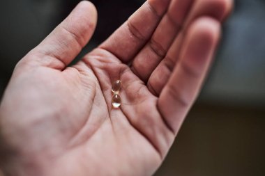 Avuç içlerine sergilenmiş D vitamini hapları. Sağlık sigortası, bağışıklık desteği, beslenme takviyeleri, sağlık ve sağlıklı yaşam tarzı kavramı. Tıbbi, farmasötik ve besinle ilgili konular için uygun temiz ve minimal bileşim.