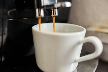 Bir fincana dökülen espresso kahvenin düşük kaliteli fotoğrafı. Kahve hazırlama, sabah rutini, kafein, kafe kültürü ve günlük yaşam tarzı kavramı. Editörel veya gerçekçi içerik için uygun otantik ve kusurlu resim.