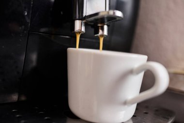 Bir fincana dökülen espresso kahvenin düşük kaliteli fotoğrafı. Kahve hazırlama, sabah rutini, kafein, kafe kültürü ve günlük yaşam tarzı kavramı. Editörel veya gerçekçi içerik için uygun otantik ve kusurlu resim.