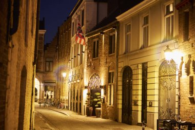 Bruges, Belçika 'nın eski tarihi mimarisi. Gece sokak ışıklarıyla aydınlatılmış. Ortaçağ Avrupa şehrinin romantik atmosferi, seyahat ve turizm kavramı.