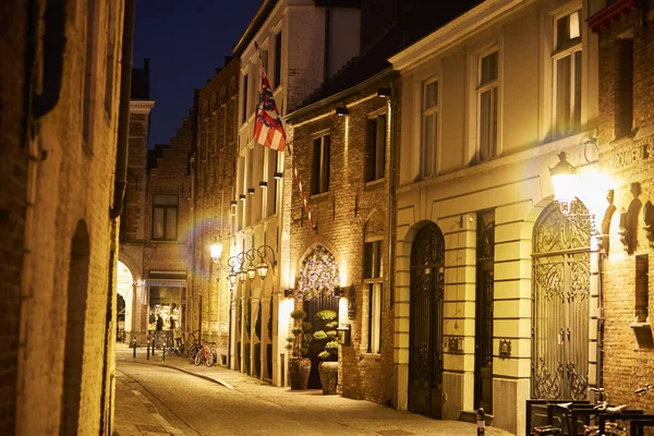 Bruges, Belçika 'nın eski tarihi mimarisi. Gece sokak ışıklarıyla aydınlatılmış. Ortaçağ Avrupa şehrinin romantik atmosferi, seyahat ve turizm kavramı.
