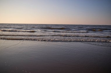 Deniz köpüğü ve dalgaların kıyıya vurduğu güzel kayalık sahilde gün doğumu. Barents Denizi 'nde sabahın erken saatlerinde, vahşi doğa, güzel kuzey doğası..