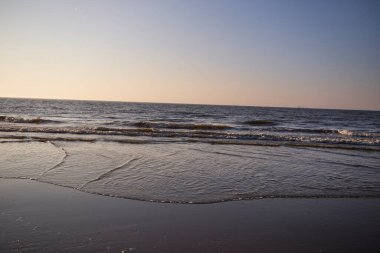 Deniz köpüğü ve dalgaların kıyıya vurduğu güzel kayalık sahilde gün doğumu. Barents Denizi 'nde sabahın erken saatlerinde, vahşi doğa, güzel kuzey doğası..