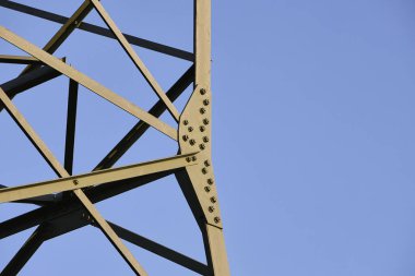 Yüksek voltajlı elektrik hatları sabah güneşinin altında Alman tepeleri boyunca uzanıyor. Enerji altyapısı, kırsal alan ve sürdürülebilir güç kavramı.