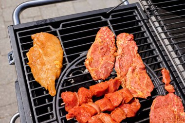 Barbekü ızgarasında cızırdayan bir sürü et. Açık hava yemekleri, yaz barbeküsü, ızgara ve lezzetli yemekler..