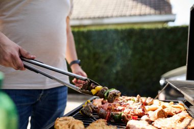 Barbekü ızgarasında cızırdayan bir sürü et. Açık hava yemekleri, yaz barbeküsü, ızgara ve lezzetli yemekler..