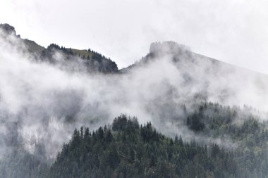 Görkemli dağ zirveleri, yemyeşil yamaçlar ve mavi gökyüzünde sürüklenen dramatik bulutlarla İsviçre Alpleri 'nin nefes kesici yaz manzarası. Bu doğal manzara, yazın İsviçre 'nin güzelliğini, tazeliğini ve huzurunu yansıtıyor.