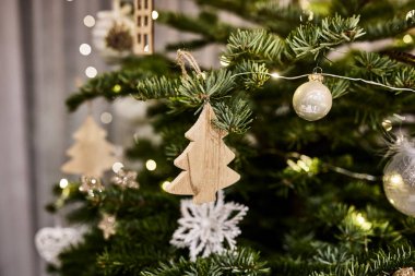 Noel süsleri süslenmiş bir Noel ağacına asılıydı. Geleneksel Yeni Yıl dekorasyonları, ışıklar ve mevsimsel sıcaklıkla bir tatil atmosferi yakalıyor. Kış tatili kavramı, kutlama, neşe, aile gelenekleri