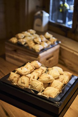 İsviçre 'de bir otelde kahvaltı servisi, taze yemek sunan insanların ellerini gösteriyor. Sahne konukseverliği, kaliteli hizmeti ve rahat bir seyahat deneyimini temsil ediyor. Turizm, otel yaşam tarzı, yemek ve diğer konular için ideal.