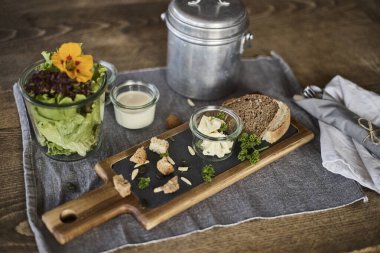 İsviçre 'de bir otelde kahvaltı servisi, taze yemek sunan insanların ellerini gösteriyor. Sahne konukseverliği, kaliteli hizmeti ve rahat bir seyahat deneyimini temsil ediyor. Turizm, otel yaşam tarzı, yemek ve diğer konular için ideal.