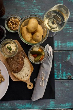 Gün batımında açık havada eritilmiş peynir, patates ve şarapla geleneksel bir İsviçre yemeği. Arka plandaki alp dağları, otantik İsviçre mutfağıyla doğal güzelliği birleştirerek sıcak ve rahat bir atmosfer yaratırlar. Konseptler için mükemmel