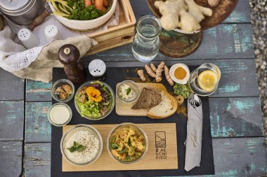 Gün batımında açık havada eritilmiş peynir, patates ve şarapla geleneksel bir İsviçre yemeği. Arka plandaki alp dağları, otantik İsviçre mutfağıyla doğal güzelliği birleştirerek sıcak ve rahat bir atmosfer yaratırlar. Konseptler için mükemmel