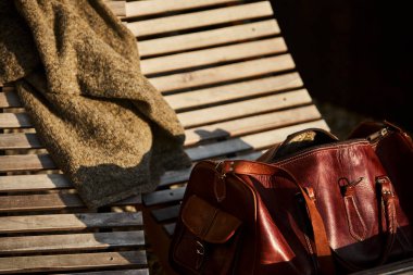 İsviçre 'de bir otelin yanındaki sandalyede dinlenen deri bir çanta. Yanında da deri kaplı bir seyahat defteri. Sahne macera, turizm ve İsviçre 'de şık bir seyahat yaşam tarzını çağrıştırıyor. Seyahat kavramları ve Avrupa turizmi için uygundur