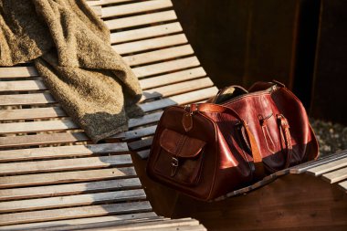 İsviçre 'de bir otelin yanındaki sandalyede dinlenen deri bir çanta. Yanında da deri kaplı bir seyahat defteri. Sahne macera, turizm ve İsviçre 'de şık bir seyahat yaşam tarzını çağrıştırıyor. Seyahat kavramları ve Avrupa turizmi için uygundur