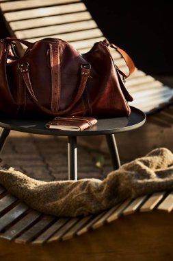 İsviçre 'de bir otelin yanındaki sandalyede dinlenen deri bir çanta. Yanında da deri kaplı bir seyahat defteri. Sahne macera, turizm ve İsviçre 'de şık bir seyahat yaşam tarzını çağrıştırıyor. Seyahat kavramları ve Avrupa turizmi için uygundur