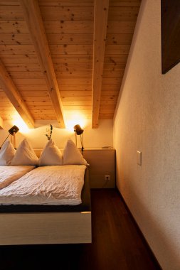 Rahat bir yatak odası ve manzaralı bir dağ manzaralı bir İsviçre otel odası atmosferi. İçerisi konforu, konukseverliği ve rahatlatıcı bir alp konaklamasını yansıtıyor. Seyahat konaklama, turizm, rahatlama ve Avrupa 'ya uygun konseptler